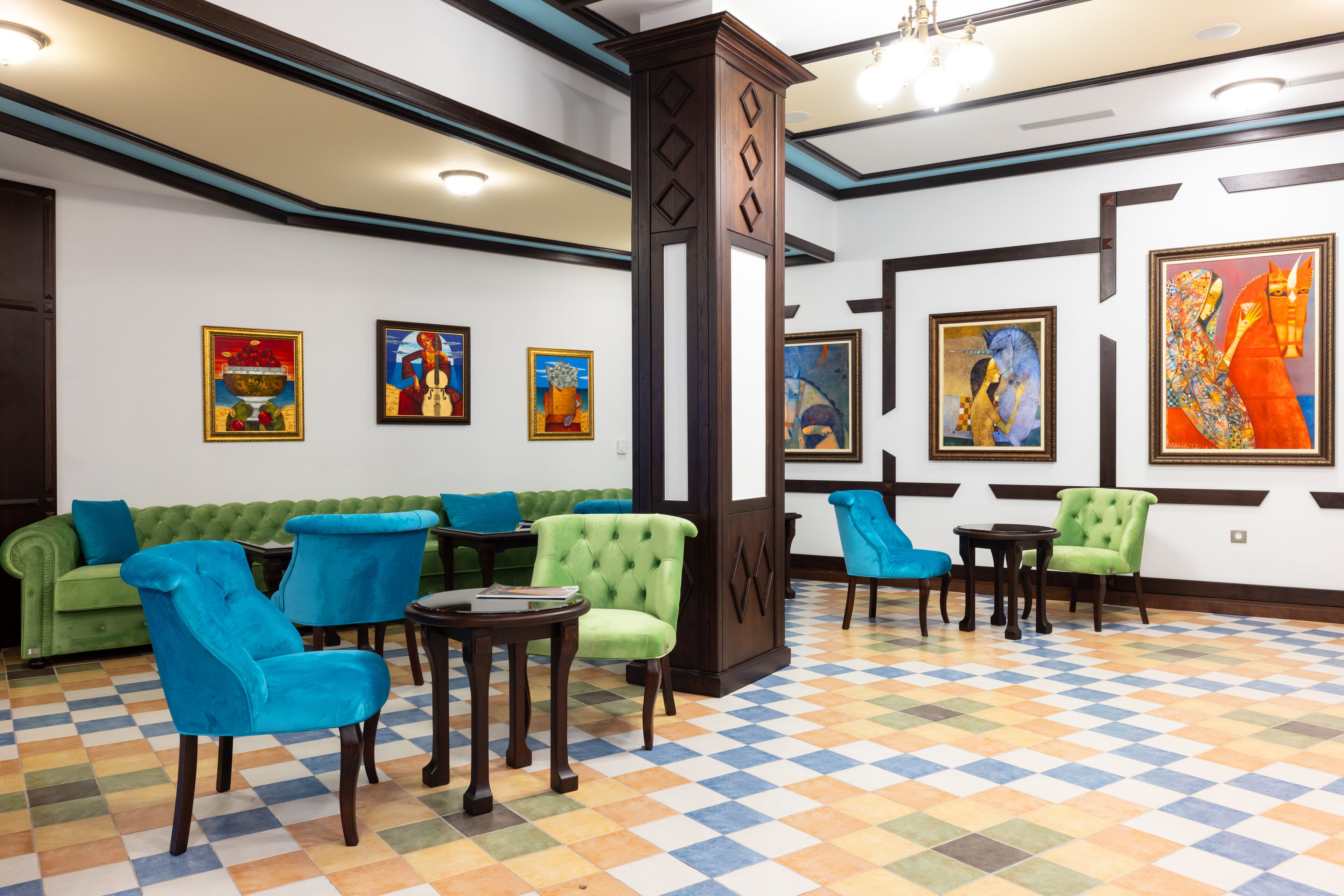 A lobby with a green sofa, blue chairs, and a checkered floor.
