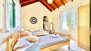 A bedroom with two beds, wooden ceiling beams, a large mirror, and a view of the outdoors. - Renas Studio near Roda (Roda)