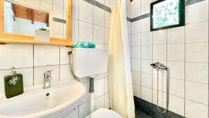A bathroom with a sink, toilet, shower, and a mirror. - Renas Studio near Roda (Roda)