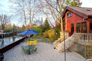 A waterfront property with a dock, outdoor seating, and a wooden deck.