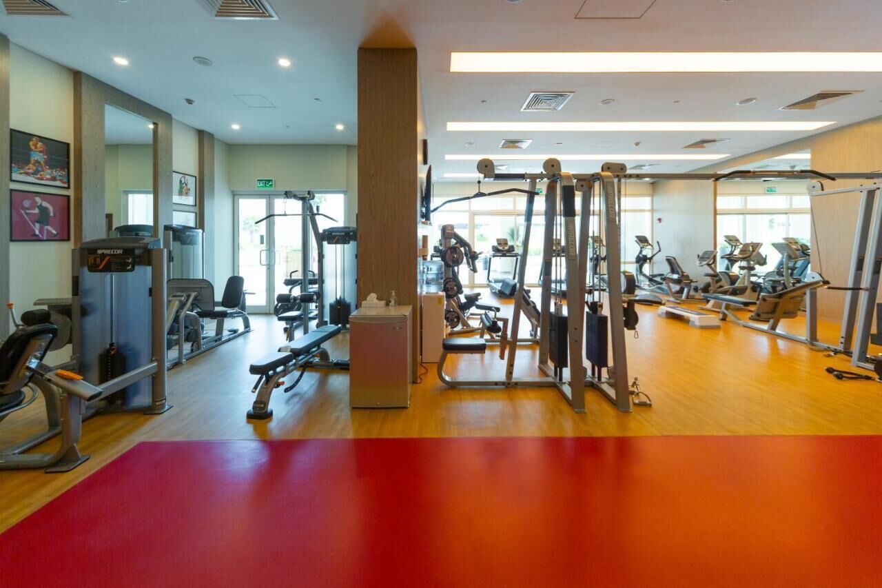 Une salle de sport équipée de divers appareils d’exercice, notamment des tapis de course et des appareils de musculation.