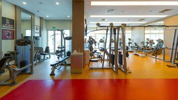 Une salle de sport équipée de divers appareils d’exercice, notamment des tapis de course et des appareils de musculation.
