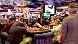 Un casino con varias mesas de juego y máquinas tragamonedas.