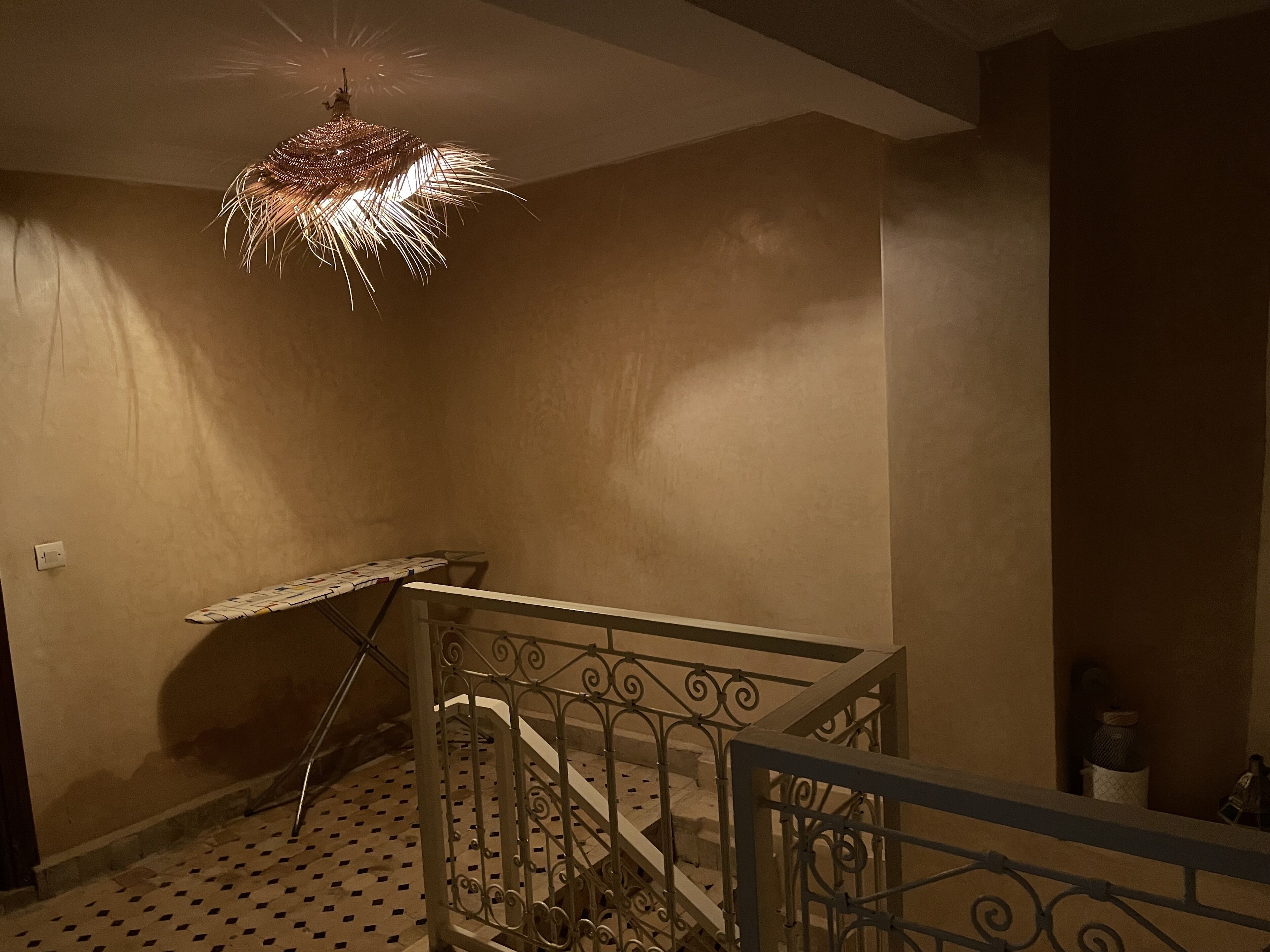 A staircase with a patterned floor and a metal railing.