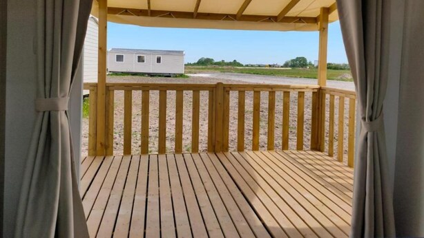 A wooden deck with a canopy, leading to a white mobile home in a rural setting. - Mobile Home 6 Domaine DE LA Grange DES Champs (Lorris)