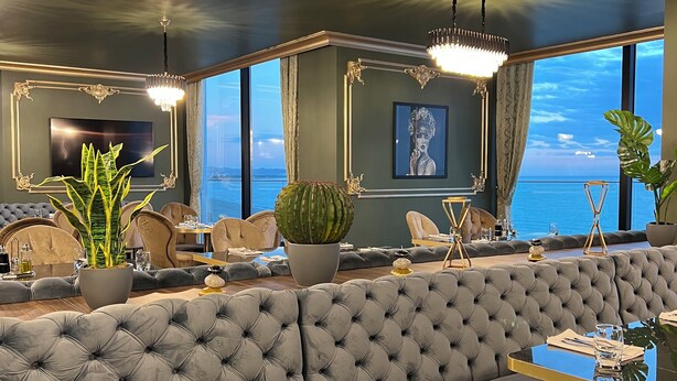 A luxurious seating area with a marble table, elegant lighting, and a view of the sea. - Luxury Premium Finese Hotel & SPA (Golem)