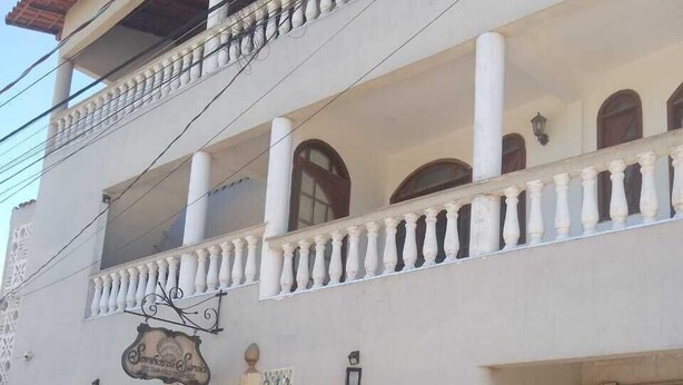 Un bâtiment à deux étages doté d’un balcon, de grandes fenêtres et d’une enseigne.