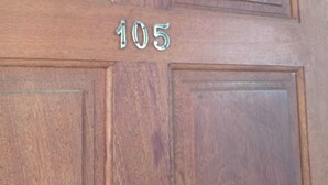 Une porte en bois portant le numéro 105.