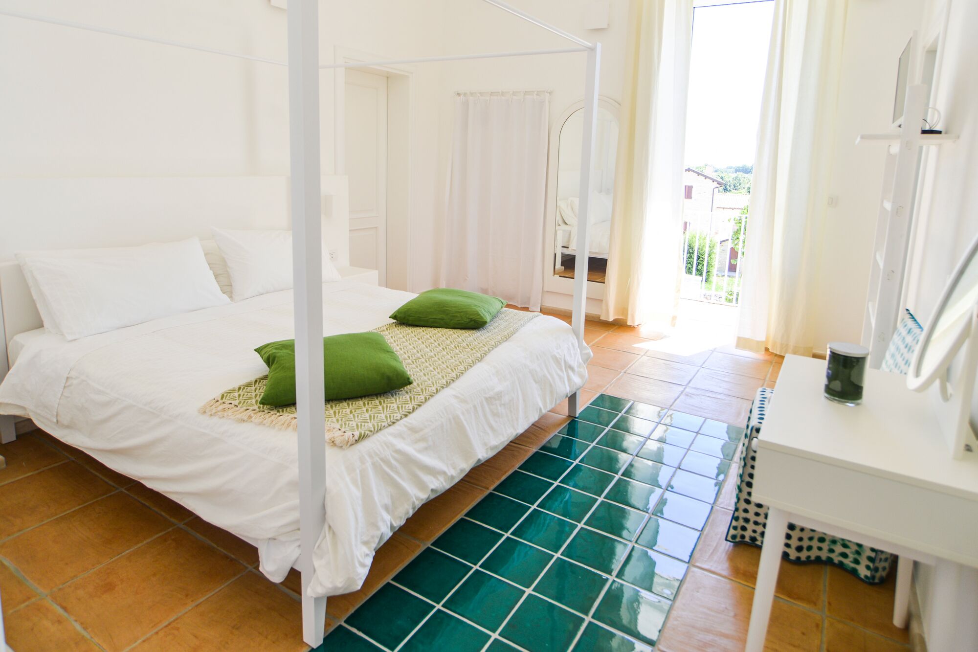 Ein Schlafzimmer mit einem Bett, zwei Kissen, einem Nachttisch und einem Fenster mit Vorhängen.