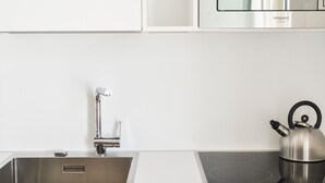 A modern kitchen with a stainless steel sink, a kettle, and a built-in stovetop. - Masseria Torrechiara Eco Dimora di Charme. (Corato)