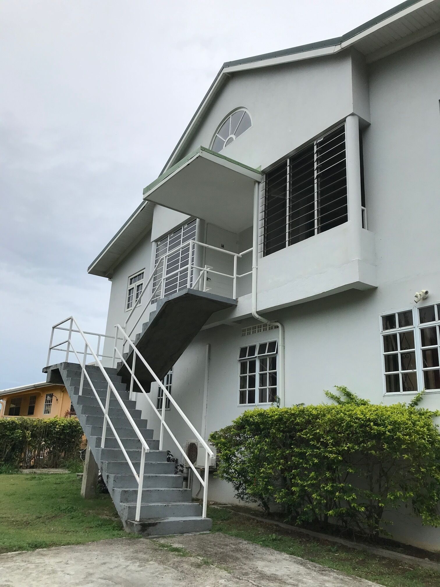 Un bâtiment à deux étages avec un escalier menant à un balcon.