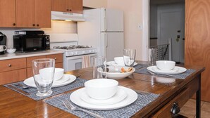 A modern kitchen with wooden cabinets, a microwave, stove, and a refrigerator. - Bryn Mawr Has It All (Bryn Mawr)