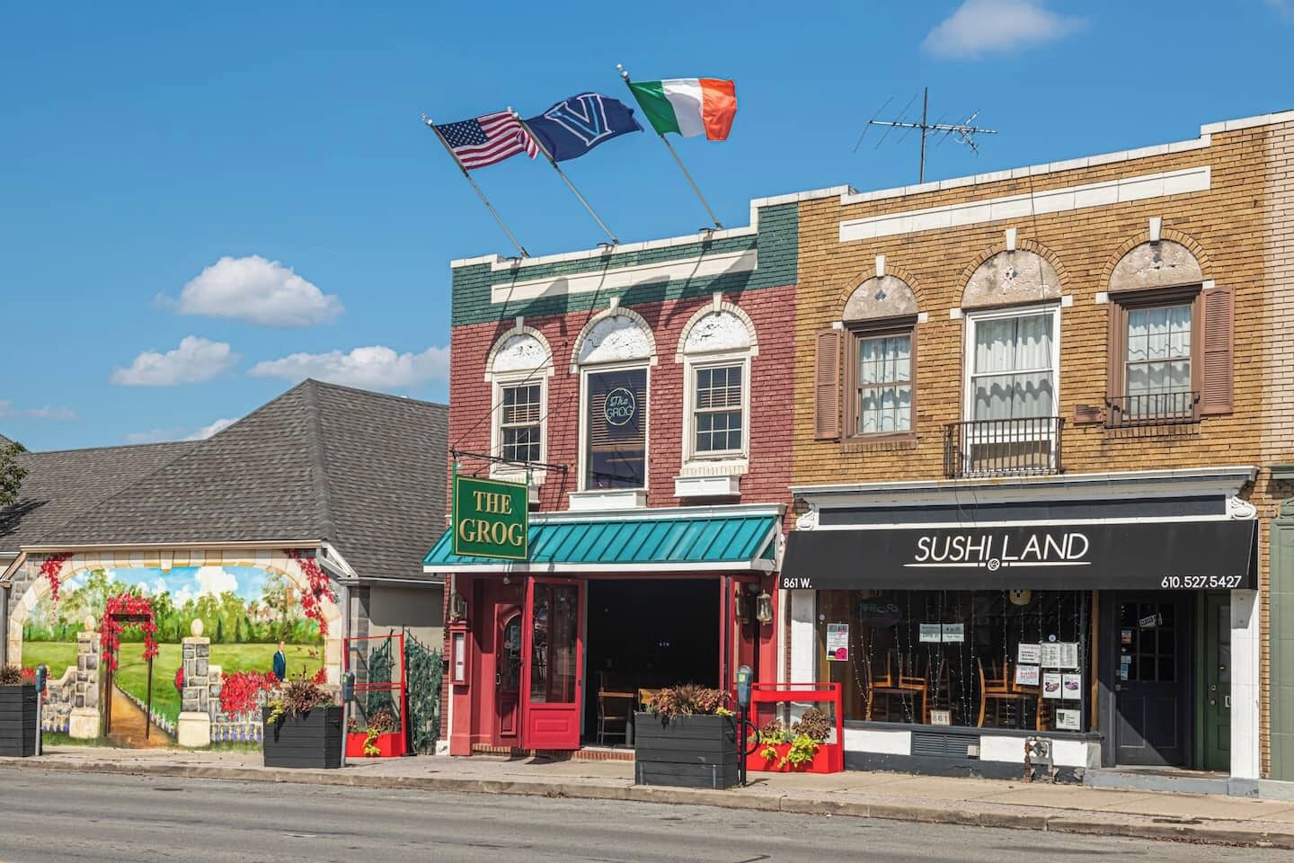 A street view with buildings, including a restaurant named 'The Grog' and a sushi restaurant named 'SUSHI LAND'.
