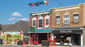 A street view with buildings, including a restaurant named 'The Grog' and a sushi restaurant named 'SUSHI LAND'.