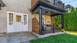 Une maison à deux étages avec un porche couvert, un garage et une pelouse bien entretenue.