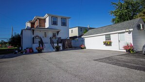 A two-story house with a front porch, a small attached garage, and a driveway. - Devon - Horse Show, History, Walk to Shops, Café's (Devon)