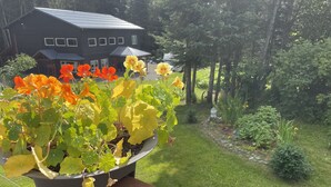 A potted plant with orange and yellow flowers on a wooden deck. - Cranes' Rest: Cozy Homer Family Home Near Downtown & the Spit (Homer)