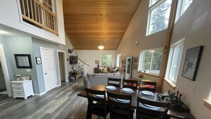 A spacious dining area with a high ceiling and large windows. - Cranes' Rest: Cozy Homer Family Home Near Downtown & the Spit (Homer)