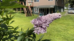 A house with a wooden deck, a staircase, and a car parked in front. - Cranes' Rest: Cozy Homer Family Home Near Downtown & the Spit (Homer)