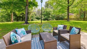 Un espace extérieur aménagé avec des meubles en osier et un lampadaire.