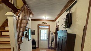 A wooden staircase leading to a landing, a hallway with a rug, and a door with a window. - Whole House Rental - Private Cottage near Historic Hermann, Missouri (Hermann)