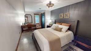 A bedroom with a bed, a desk, a chair, a mirror, and a door. - Colby Cottage in Taylors Falls, 4 Bedroom Home - Walk to Interstate Park (Taylors Falls)