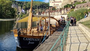 Un barco llamado 'Caminade Jean' atracado en un muelle con un cartel que indica 'Caminade Jean'.