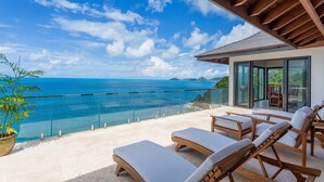 A balcony with lounge chairs overlooking a clear blue sea and distant mountains. - Maxi Cooper Bay (Road Town)