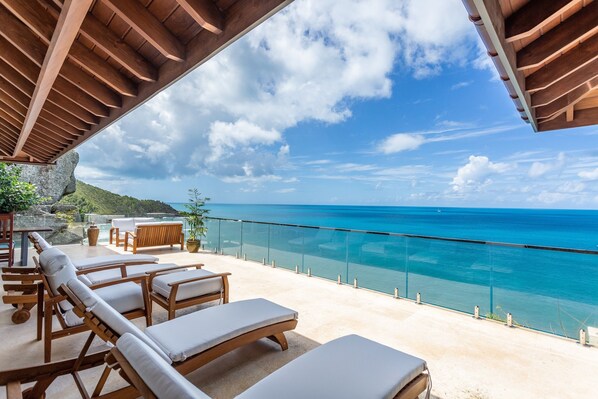 A wooden deck with lounge chairs overlooking a turquoise sea. - Villa Maxi Cooper (Road Town)
