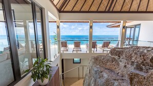 A modern interior with a staircase leading to a balcony overlooking the ocean. - Maxi Cooper Bay (Road Town)