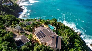 A coastal property with a swimming pool, solar panels, and a view of the ocean. - MyALL Tortola (Road Town)