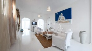 A spacious, modern living room with white furniture, a large painting, and a view of the sea. - Attico Barca by BarbarHouse (Gallipoli)