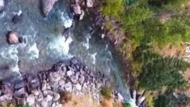 A river flowing through a forested area with a rocky path and a small waterfall. - Black Bear primitive campsite with
Mineral rights. (Howardsville)