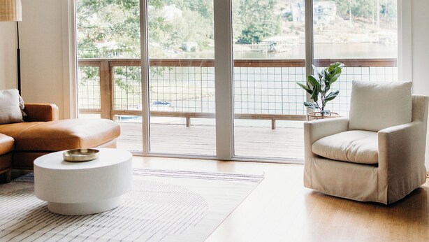 A spacious room with a large window, a ceiling fan, and a view of a balcony.
