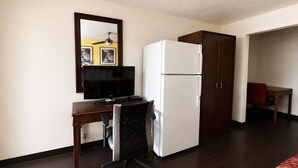 A hotel room with a desk, chair, refrigerator, wardrobe, and a bed. - Vernals Best Value Inn (Vernal)