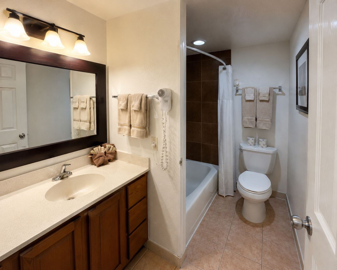 Une salle de bain équipée d’un lavabo, d’un miroir, d’un porte-serviettes, d’une douche et de toilettes.