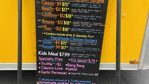 A menu board for a food truck listing various beef and chicken burgers, specialty fries, and a kids meal. - Vernals Best Value Inn (Vernal)