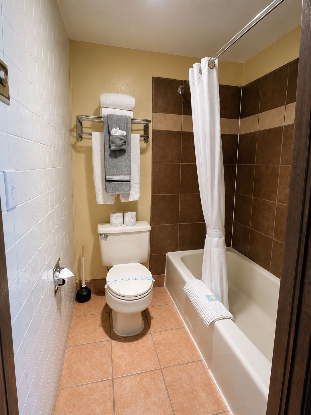 A bathroom with a toilet, a bathtub, and a shower curtain.
