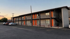 A multi-story motel with a parking lot, featuring a central staircase and balconies. - Vernals Best Value Inn (Vernal)