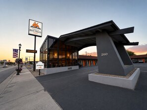 A modern hotel with a large entrance, a sign indicating a vacancy, and a prominent address number. - Vernals Best Value Inn (Vernal)