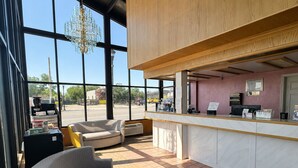 A modern interior with a seating area, a counter, and large windows. - Vernals Best Value Inn (Vernal)