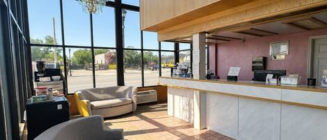 A modern interior with a seating area, a counter, and large windows.