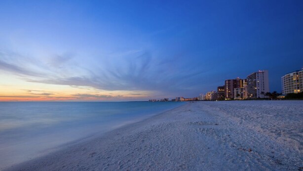 A beach with a clear sky and buildings in the background. - Stunning Sunsets, Spacious Waterfront Home (Marco Island)
