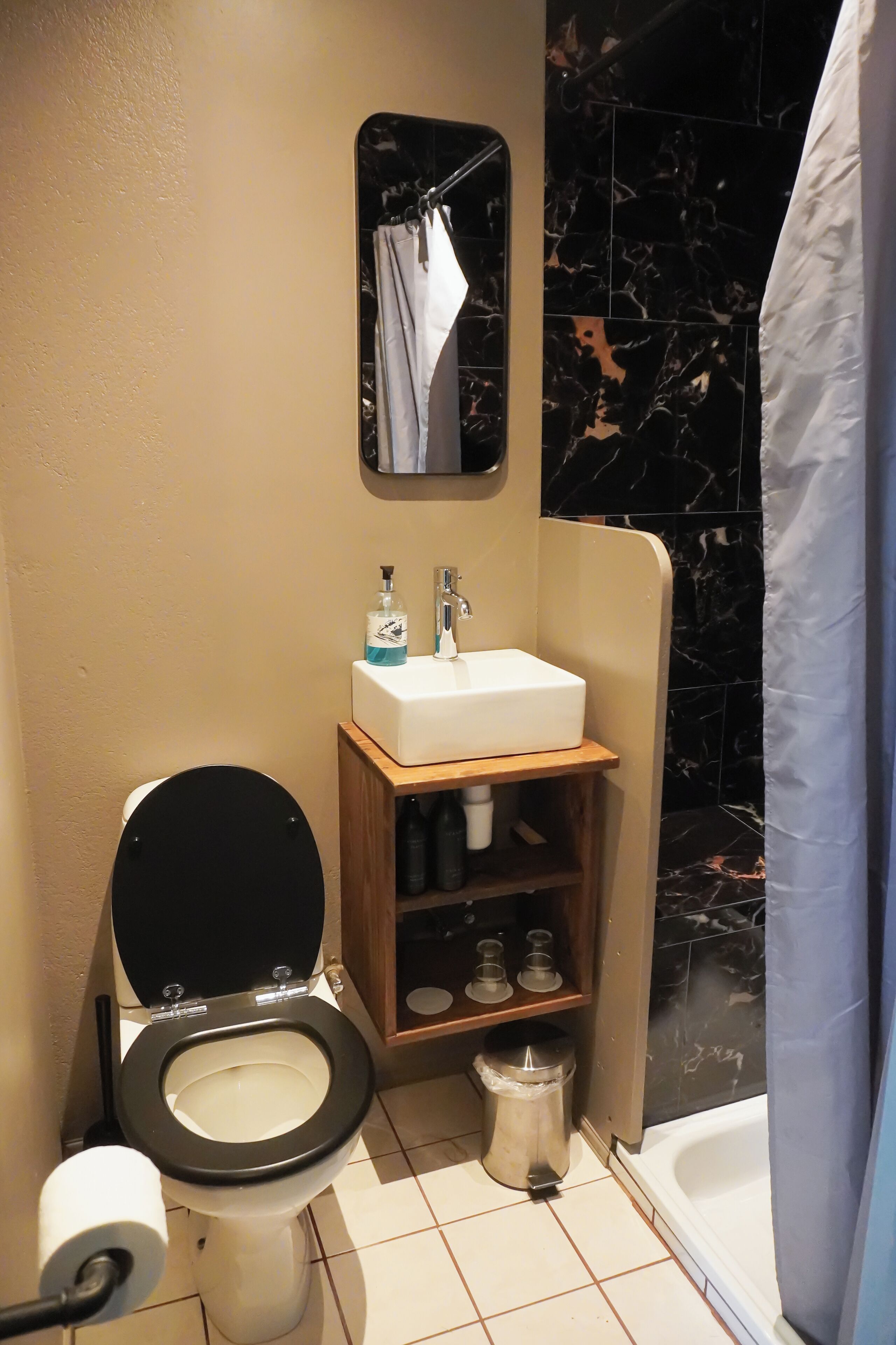 A compact bathroom with a toilet, sink, and shower area.