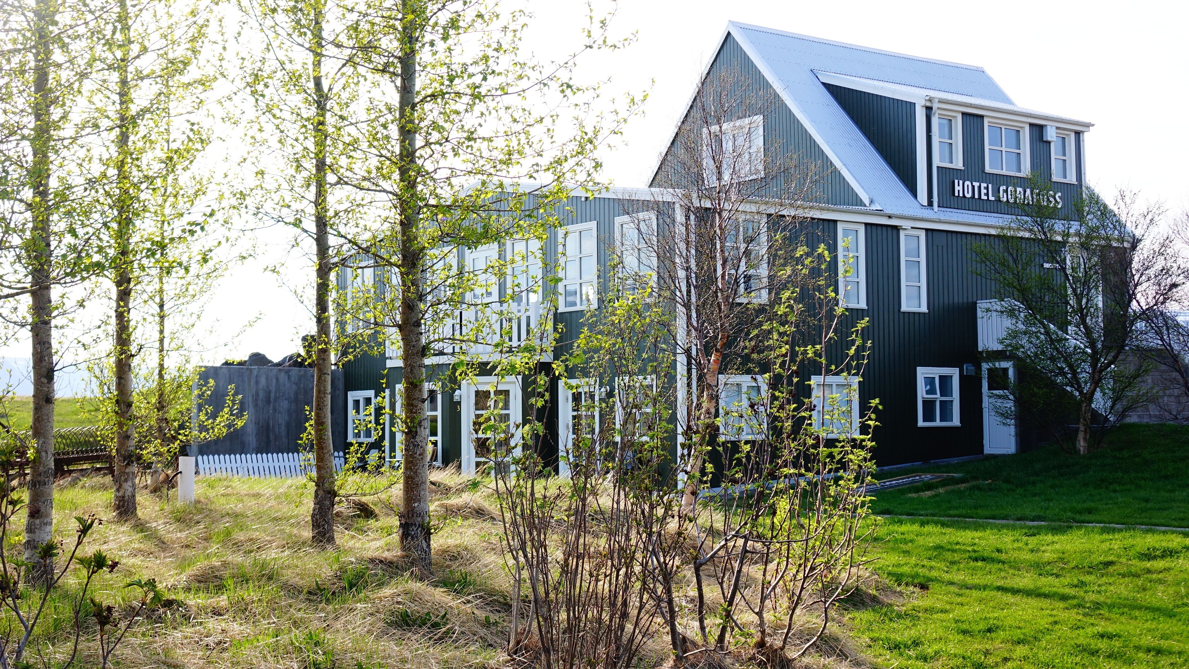 Un hôtel moderne à la façade sombre et aux ornements blancs, doté de nombreuses fenêtres et d’une enseigne bien visible.