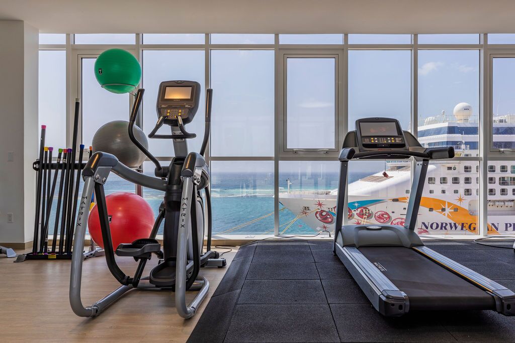 A gym with cardio equipment, a rowing machine, and a stationary bike.