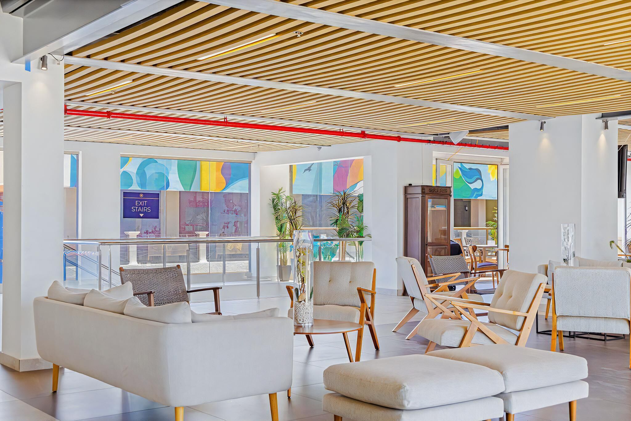 A spacious lobby with modern seating, large windows, and a wooden ceiling.