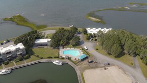 Ein Luftbild einer Küstenimmobilie mit einem Hafen, einem Schwimmbad und einem Parkplatz.