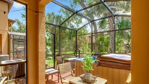 Eine sonnendurchflutete Terrasse mit Glasveranda, Korbmöbeln und einem Blumentopf.
