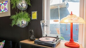 A room with a turntable, a record player, a lamp, and a window with a view.
